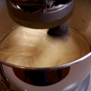 The image shows combined butter and syrup for french buttercream recipe