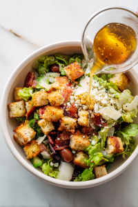 Dress to Impress: Pour that luscious dressing over the salad and give it a toss until every leaf and crouton is coated in flavorful elegance.