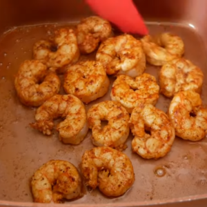 The image shows the process of pan frying the shrimp