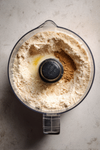 Add baking powder, baking soda, cinnamon (optional), salt, eggs, 1 1/2 cups buttermilk, oil or melted butter, honey, and vanilla to the processor. Blend well.