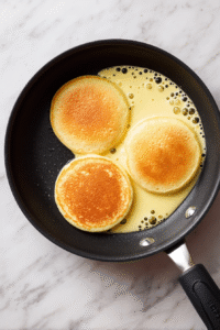 Ladle 1/3 cup batter onto skillet, spread into 4-inch circles. Cook for 2-3 mins until bubbles form, then flip and cook 2 more mins until golden brown.