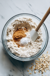 Combine Dry Ingredients: Add the flour, oats, cinnamon, baking soda, and salt to the mixture. Stir just until the dry ingredients are incorporated.