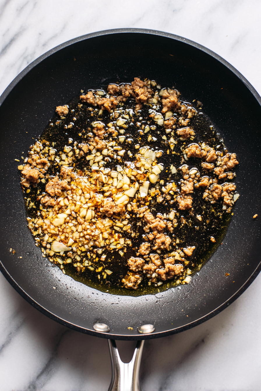 Cook the Meat: Heat vegetable oil in a pan over medium heat. Add minced garlic and ginger, then add the minced pork or beef. Cook until the meat is browned.