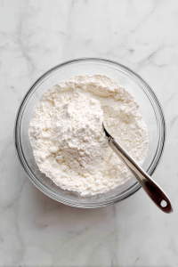 In a large bowl, mix 2 cups of all-purpose flour and ½ teaspoon of fine salt. Cut in ½ cup of shortening using a pastry cutter or bread knife until it forms small pieces.