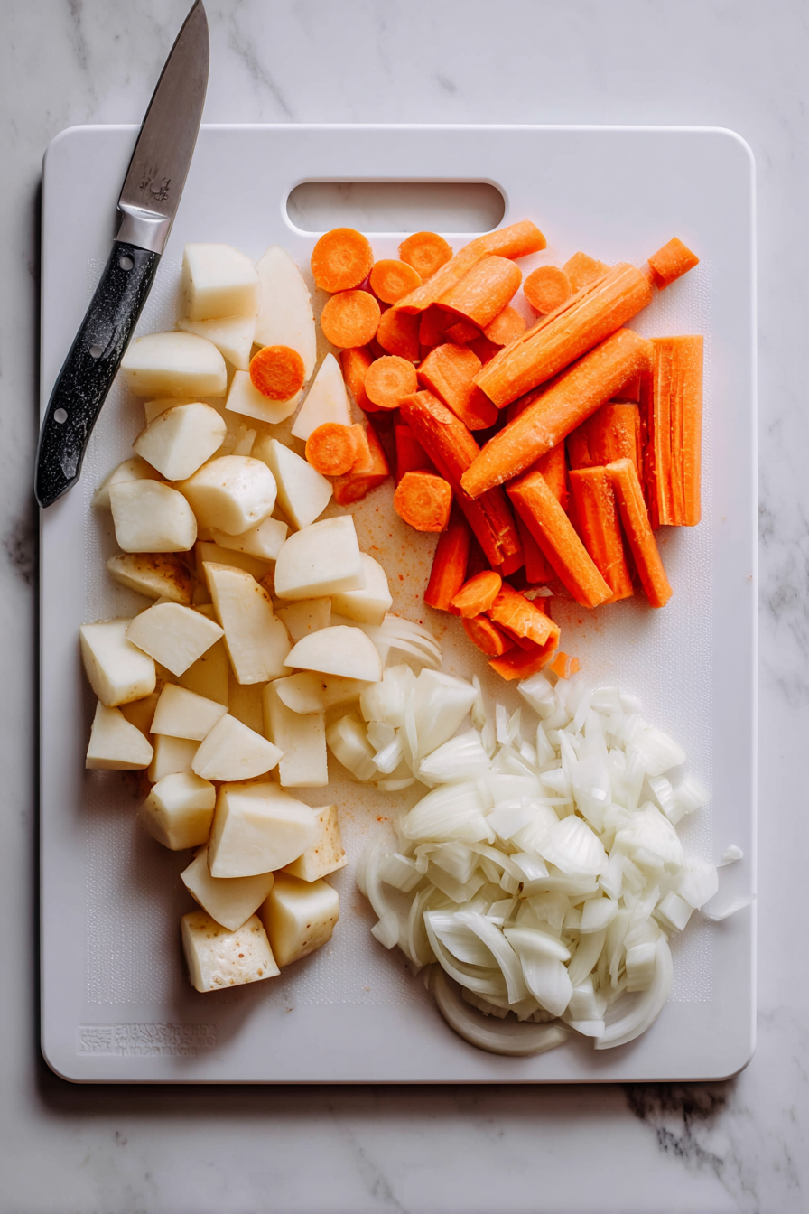 Prepare the vegetables: Peel and slice the carrots, peel and cut the potatoes into chunks, and slice the onion.