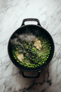 Season and simmer: Add herbs like thyme and bay leaves, along with salt and pepper to taste. Optionally, add diced meat like ham or bacon for flavor. Bring the mixture to a boil, then reduce the heat and simmer uncovered for 1 to 1.5 hours, or until the peas are soft and the soup has thickened.