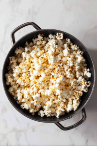 Once the kernels start popping, gently shake the pot occasionally to prevent burning.