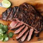 This image shows the juicy Ranchera Meat served on a plate, garnished with fresh herbs and sides, highlighting the delicious, savory, and citrusy flavors of the dish.