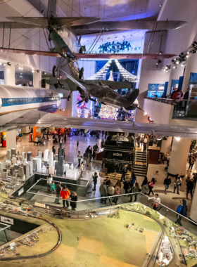 A striking view of the Museum of Science and Industry in Chicago, featuring its grand architecture and expansive grounds. This renowned museum is known for its interactive exhibits and educational experiences that engage visitors of all ages. The image highlights the museum’s iconic dome and impressive facade against a clear blue sky.