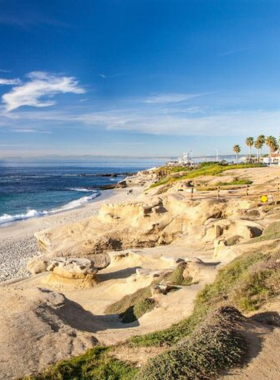 A scenic view of La Jolla Cove in San Diego, highlighting its rugged coastline, clear blue waters, and unique rock formations. The cove is a popular destination for swimming, snorkeling, and observing marine wildlife. This image captures the natural beauty and allure of La Jolla Cove, a cherished coastal gem in San Diego.