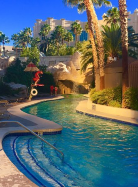 mandalay-bay-beach.jpg Sandy beach and pool area at Mandalay Bay Resort in Las Vegas, featuring palm trees, crystal-clear water, and a relaxing tropical ambiance for guests.