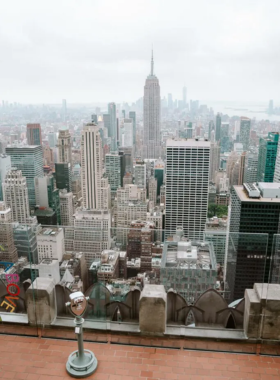 Rockefeller_Center_Ice_Rink_Winter Winter scene of the Rockefeller Center ice rink in New York City, surrounded by holiday decorations and festive lights beneath towering skyscrapers.
