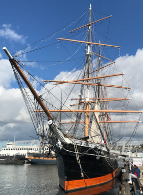 The Star of India, a historic sailing ship docked at the San Diego Maritime Museum. The image highlights the tall masts and intricate rigging of this 19th-century vessel, which has been carefully preserved as a museum exhibit. The Star of India offers visitors a unique opportunity to explore maritime history.