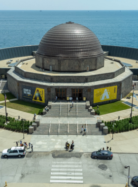 A captivating view of the Adler Planetarium, located on the shores of Lake Michigan in Chicago. The image highlights the planetarium's distinctive dome and modern architecture against a backdrop of the city skyline. This iconic venue is dedicated to astronomy and space exploration, making it a favorite destination for science enthusiasts and families alike.