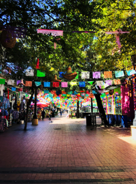 Lively outdoor market square with local shops A bustling outdoor marketplace filled with shops, food stalls, and local vendors. People are seen exploring the vibrant square, creating a lively atmosphere filled with community spirit.