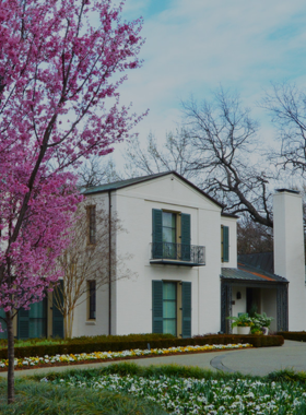Dallas_Arboretum_Camp_Entrance.jpg "Entrance to the Dallas Arboretum camp area, showcasing a stone pathway surrounded by vibrant plants, trees, and a welcoming natural environment."