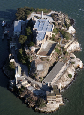 Aerial_Alcatraz_Island.jpg An aerial view of Alcatraz Island, featuring the historic prison building and surrounding waters. The rugged terrain and lush greenery contrast with the stark architecture of the prison, highlighting its historical significance.