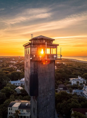 Sunset_at_Sullivans_Island.jpg A stunning sunset over Sullivan’s Island, with the sun casting a warm glow over the tranquil waters. Silhouettes of palm trees frame the beach, creating a peaceful and picturesque scene of Charleston’s coastline.