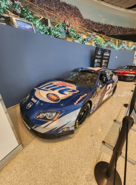NASCAR-Hall-of-Fame-Interactive-Exhibits-Racing-History This image shows that visitors are discovering the history of NASCAR through immersive, interactive exhibits at the NASCAR Hall of Fame, learning about famous drivers and iconic cars in racing history.