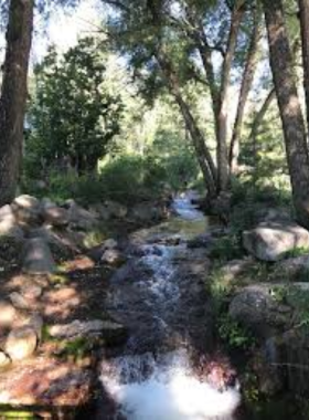north-cheyenne-canon-helen-hunt-falls.jpg This image shows the beautiful Helen Hunt Falls in North Cheyenne Cañon Park, cascading down rocky cliffs into a tranquil pool surrounded by green trees.