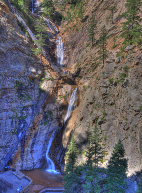 seven-falls-waterfalls-canyon.jpg This image shows the cascading waterfalls of Seven Falls, with water tumbling down a steep canyon surrounded by tall cliffs and vibrant greenery.