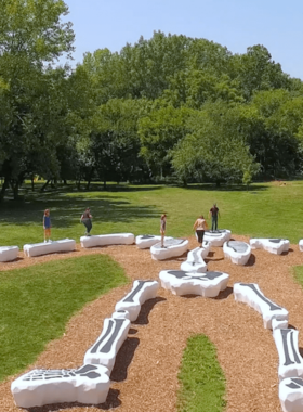 Newfields Art Museum and Gardens "This image shows the beautiful gardens and art exhibits at Newfields, with visitors exploring the outdoor sculptures and lush greenery."