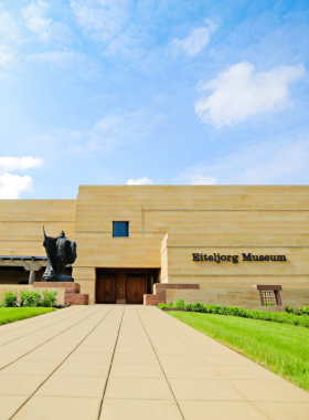 Eiteljorg Museum Exterior with Native Art "This image shows the Eiteljorg Museum’s unique architecture, with Native American art sculptures outside welcoming visitors."