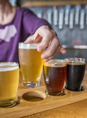 Explore the Local Breweries "This image shows a local Asheville brewery, with people enjoying craft beers and a cozy, inviting atmosphere."