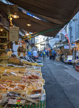tsukiji-outer-market-breakfast-sushi.jpg This image shows the vibrant Tsukiji Outer Market where visitors enjoy fresh sushi for breakfast. The market is bustling with people, vendors selling seafood, and colorful stalls offering sushi delicacies. The fresh seafood on display highlights the authenticity and variety of Tokyo’s seafood cuisine.