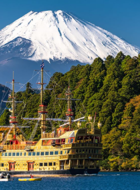 mount-fuji-scenic-day-trip.jpg This image shows Mount Fuji in the distance, with clear skies and scenic landscapes surrounding the iconic peak. Visitors are seen enjoying a day trip to Mount Fuji, either hiking or sightseeing by the lakes, with breathtaking views of the mountain that are especially striking on clear days.