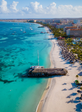 palm-beach-aruba-water-activities.jpg This image shows that Palm Beach in Aruba is a lively location filled with water sports, clear blue waters, and people enjoying beach activities. The vibrant atmosphere makes it a top destination for tourists.