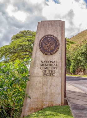 National Memorial Cemetery of the Pacific This image shows the National Memorial Cemetery of the Pacific, located in Punchbowl Crater. Rows of white headstones mark the graves of U.S. soldiers, providing a peaceful and respectful setting for reflection and remembrance.