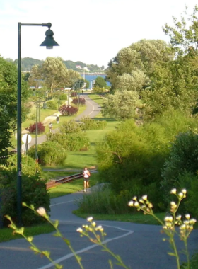 4. Eastern Promenade Trail This image shows visitors walking along the scenic Eastern Promenade Trail, surrounded by green parks and offering views of the ocean and distant islands.