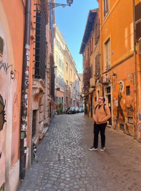 13. Visit Trastevere This image shows Trastevere, a charming district in Rome with cobbled streets, cafes, and medieval architecture.