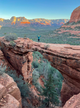 Devils-Bridge-Trail-Sedona This image shows the famous Devil’s Bridge trail in Sedona, with hikers reaching the natural sandstone arch while enjoying panoramic views of the surrounding red rocks and desert landscape.