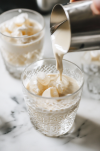 filling rimmed glasses with crushed ice for coconut mint rum cocktail