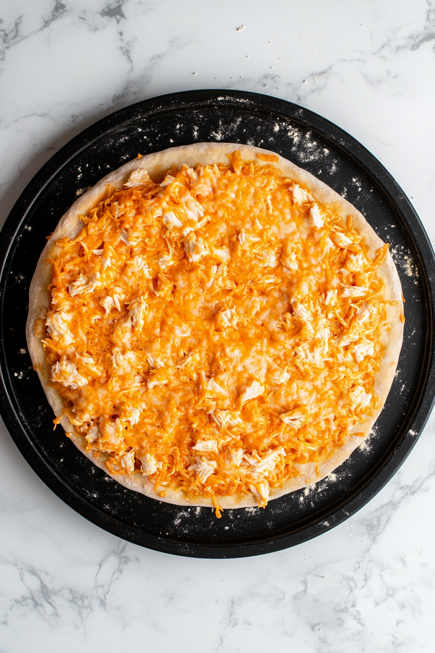 Distribute the buffalo chicken mixture evenly over the cheese.