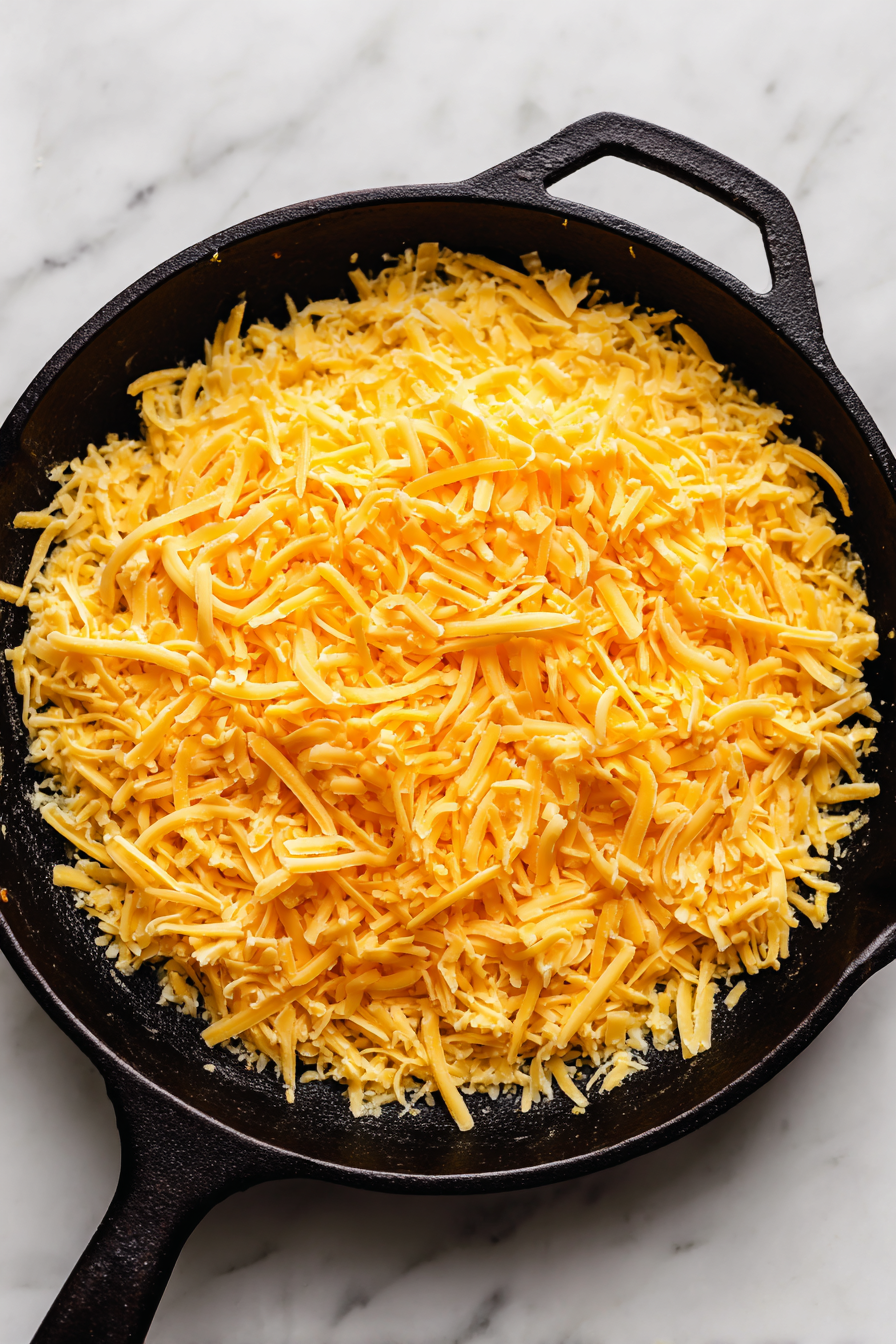 Sprinkle shredded cheddar cheese evenly over the mixture.
