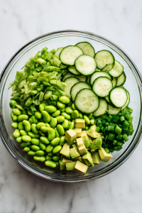 Add thawed edamame, cubed avocado, and sliced green onions.