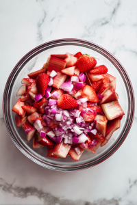 In a mixing bowl, combine rhubarb, strawberries, and onion.