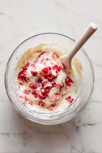 Add eggs, melted butter, milk, and vanilla to dry ingredients; stir until just combined. Fold in chopped strawberries gently.