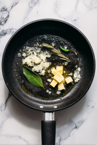 In the same pan, heat oil and butter again, and add bay leaf and green chili.