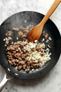 In a skillet, cook ground beef with onion and garlic until browned.