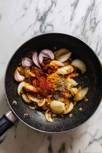 Add onions and cook until golden. Mix in turmeric, red chilli powder, and 1 tbsp of Kadai Masala.