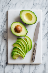 Cut the avocado in half, remove the pit, peel, and slice.