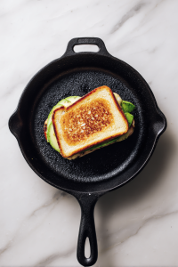 Close sandwiches and grill in the skillet, buttered side down, until bread is golden and cheese is melted.