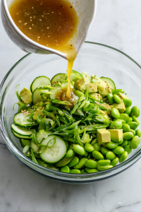 Pour the sesame-ginger dressing over the salad ingredients.