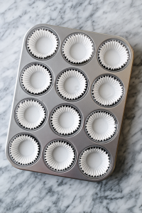 Preheat your oven to 350°F (175°C) and line a cupcake tray with liners.