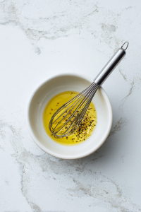 In a small bowl, whisk ⅓ cup olive oil, ⅓ cup golden balsamic vinegar, 2 tbsp lemon juice, and ¼ tsp pepper.